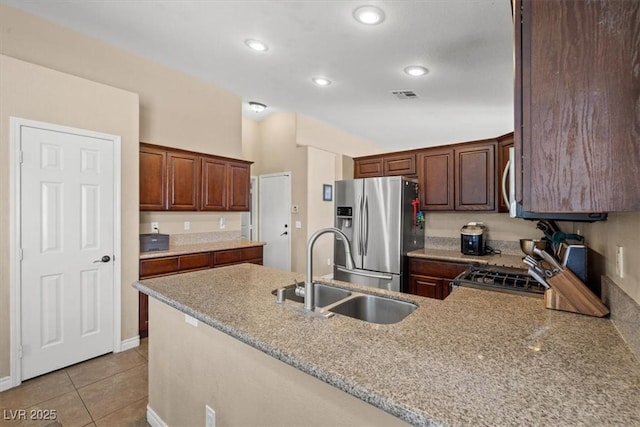 4928 Corsica Island St, North Las Vegas, NV 89031 - kitchen with appliances with stainless steel finishes, a peninsula, light tile patterned floors, recessed lighting, and light stone counters