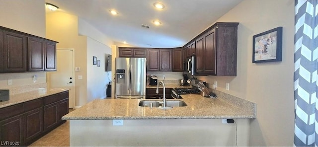 4928 Corsica Island St, North Las Vegas, NV 89031 - kitchen featuring stainless steel appliances, dark brown cabinets, a peninsula, light stone counters, and recessed lighting