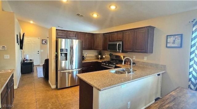 4928 Corsica Island St, North Las Vegas, NV 89031 - kitchen with appliances with stainless steel finishes, dark brown cabinetry, a peninsula, light tile patterned flooring, and recessed lighting