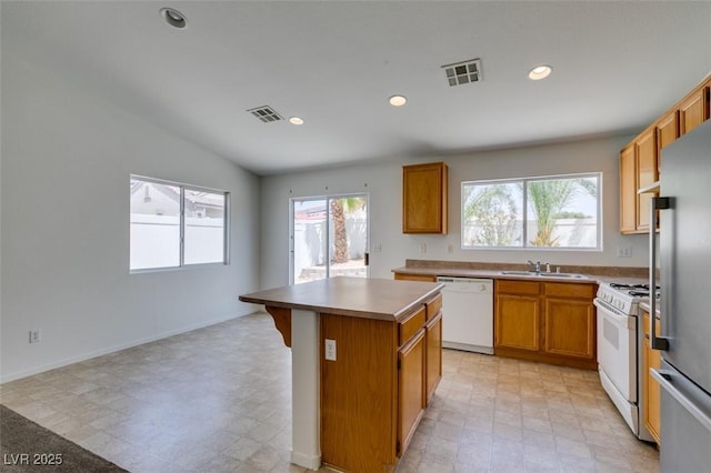 352 River Glider Ave, North Las Vegas, NV 89084 - kitchen with white appliances, a center island, light flooring, recessed lighting, and a kitchen bar