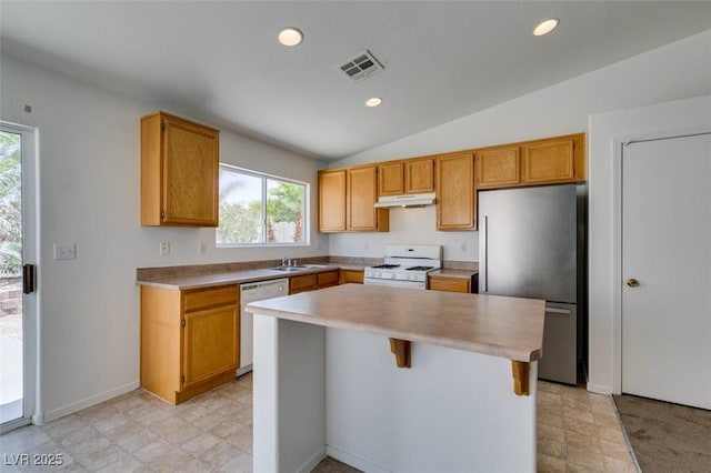 352 River Glider Ave, North Las Vegas, NV 89084 - kitchen with white appliances, light countertops, under cabinet range hood, a center island, and healthy amount of natural light