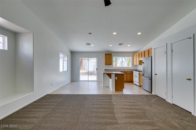 352 River Glider Ave, North Las Vegas, NV 89084 - kitchen with freestanding refrigerator, white gas range oven, open floor plan, light carpet, and recessed lighting
