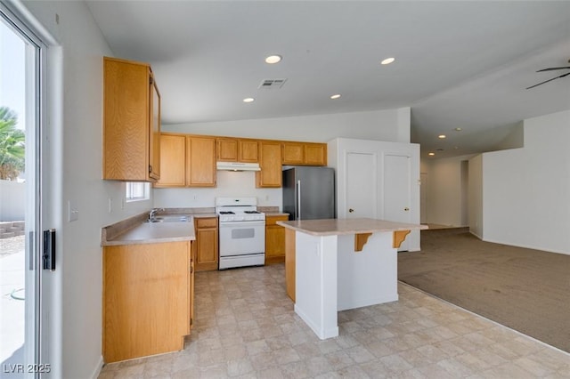352 River Glider Ave, North Las Vegas, NV 89084 - kitchen with freestanding refrigerator, gas range gas stove, under cabinet range hood, lofted ceiling, and light countertops