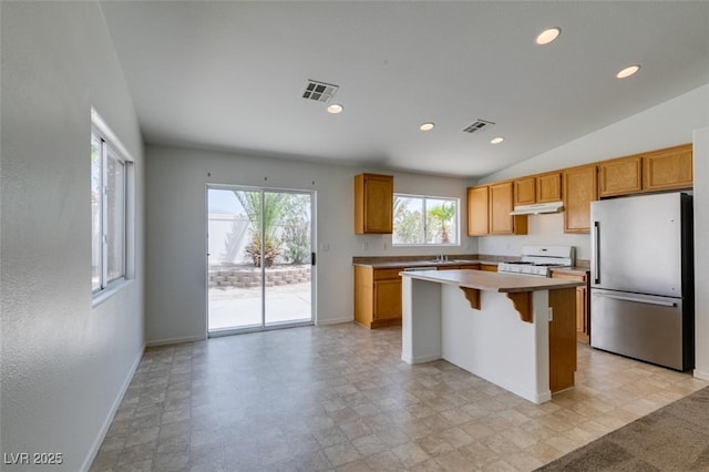 352 River Glider Ave, North Las Vegas, NV 89084 - kitchen featuring freestanding refrigerator, white gas range oven, under cabinet range hood, a center island, and light countertops