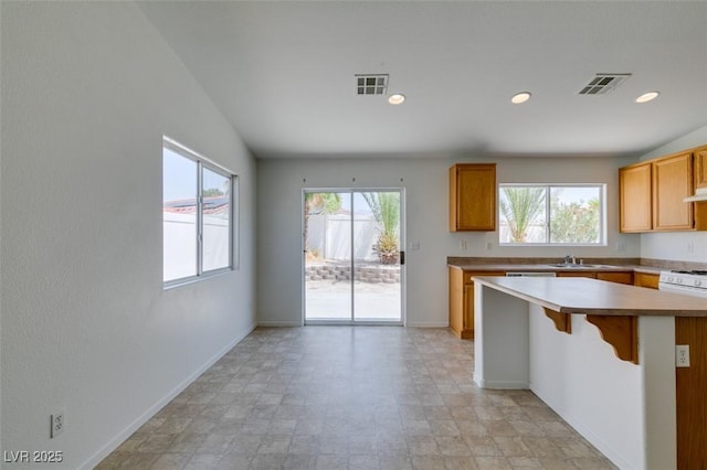 352 River Glider Ave, North Las Vegas, NV 89084 - kitchen with light countertops, a kitchen breakfast bar, recessed lighting, exhaust hood, and a kitchen island