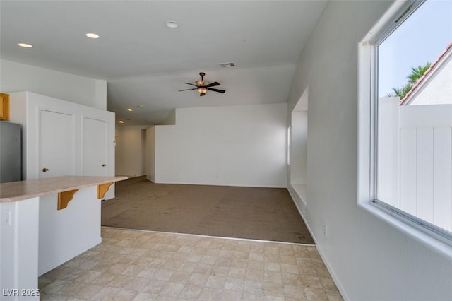 352 River Glider Ave, North Las Vegas, NV 89084 - unfurnished living room featuring a ceiling fan, plenty of natural light, recessed lighting, and light colored carpet