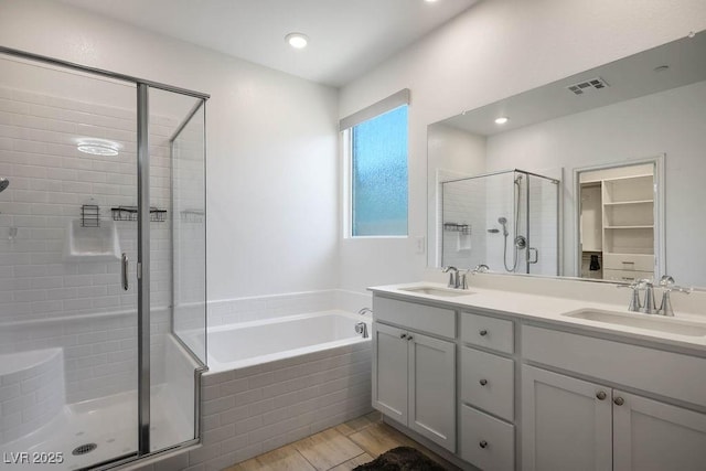 9740 Redwood Cascade St, Las Vegas, NV 89143 - full bathroom featuring a shower stall, a bath, double vanity, wood finished floors, and a spacious closet