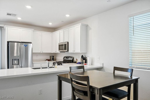 9740 Redwood Cascade St, Las Vegas, NV 89143 - kitchen featuring appliances with stainless steel finishes, white cabinetry, light countertops, healthy amount of natural light, and recessed lighting