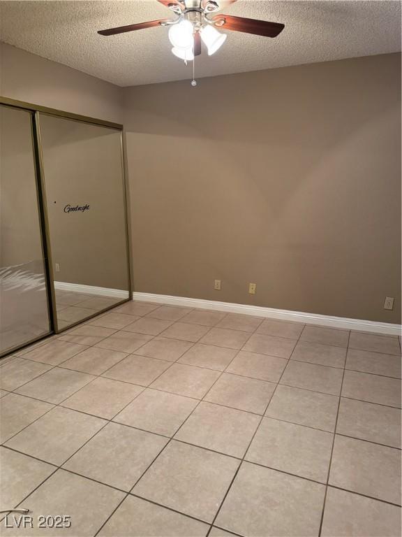 4231 Sanderling Cir Unit 267, Las Vegas, NV 89103 - unfurnished bedroom with a textured ceiling, a closet, light tile patterned floors, and ceiling fan