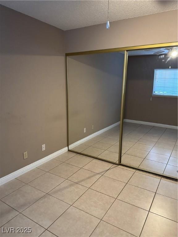 4231 Sanderling Cir Unit 267, Las Vegas, NV 89103 - unfurnished bedroom featuring light tile patterned flooring, a textured ceiling, and a closet