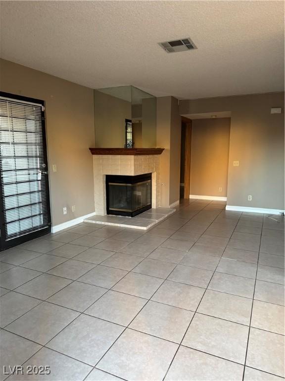 4231 Sanderling Cir Unit 267, Las Vegas, NV 89103 - unfurnished living room featuring a fireplace, a textured ceiling, and light tile patterned floors