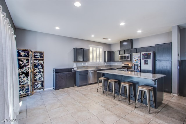 10633 Mount Blackburn Ave, Las Vegas, NV 89166 - kitchen featuring appliances with stainless steel finishes, a breakfast bar area, light tile patterned floors, recessed lighting, and a center island