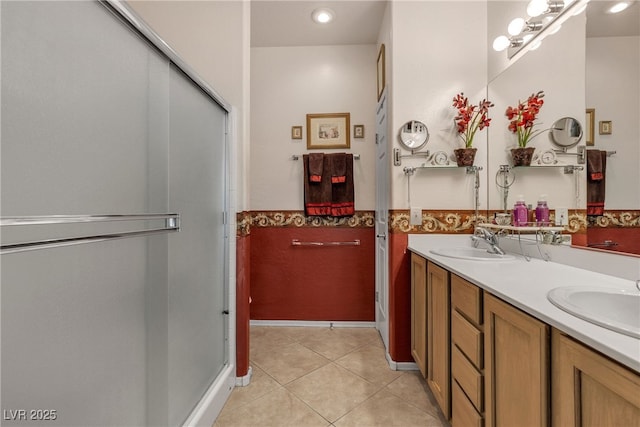 2404 Willow Wren Dr, North Las Vegas, NV 89084 - bathroom featuring double vanity, tile patterned floors, a shower stall, and wainscoting