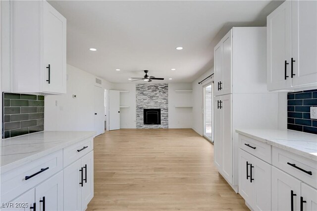 730 Arrowhead Trl, Henderson, NV 89002 - kitchen with a ceiling fan, a tile fireplace, light wood-style floors, recessed lighting, and white cabinets