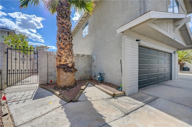 730 Arrowhead Trl, Henderson, NV 89002 - view of side of property with a garage, stucco siding, concrete driveway, and a gate
