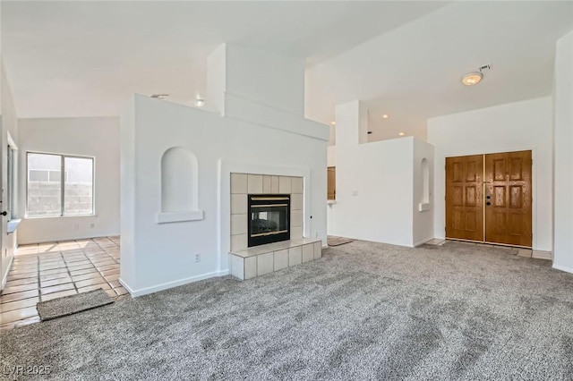 4616 Silversword Ave, North Las Vegas, NV 89032 - unfurnished living room featuring high vaulted ceiling, carpet floors, recessed lighting, and a tiled fireplace