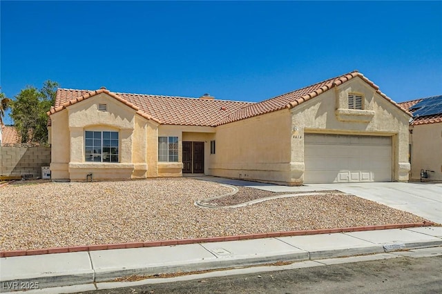 4616 Silversword Ave, North Las Vegas, NV 89032 - mediterranean / spanish home with a tiled roof, an attached garage, stucco siding, and concrete driveway