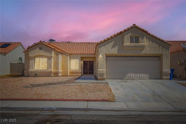 4616 Silversword Ave, North Las Vegas, NV 89032 - mediterranean / spanish home featuring a tile roof, stucco siding, driveway, and an attached garage