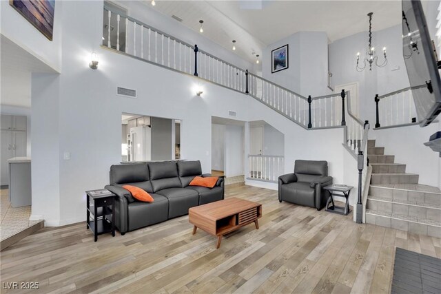 3080 Yankee Clipper Dr, Las Vegas, NV 89117 - living area with wood finished floors, a towering ceiling, a chandelier, and stairway