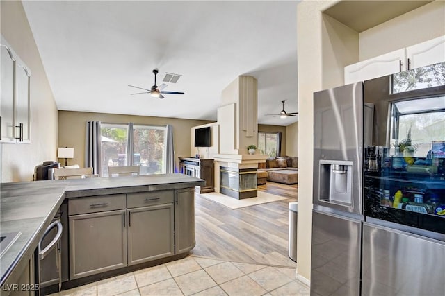 7401 Red Swallow St, Las Vegas, NV 89131 - kitchen featuring a ceiling fan, stainless steel refrigerator with ice dispenser, open floor plan, gray cabinetry, and light tile patterned floors