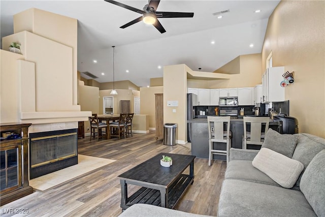 7401 Red Swallow St, Las Vegas, NV 89131 - living area with a ceiling fan, high vaulted ceiling, light wood-style flooring, and recessed lighting