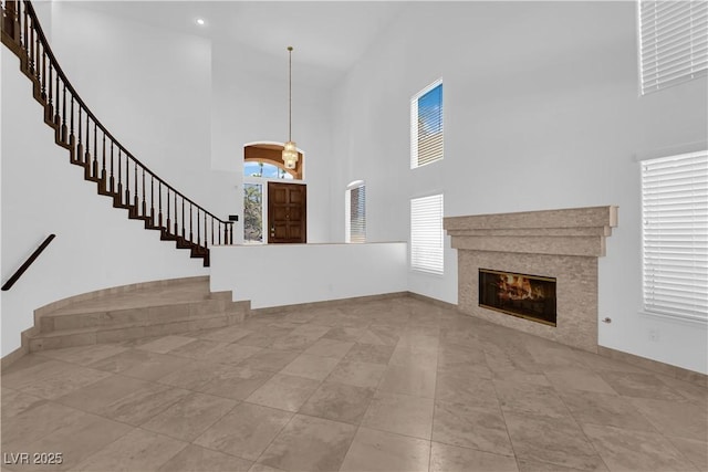 56 Grossinger Ct, Henderson, NV 89074 - unfurnished living room with a high ceiling, stairway, and a glass covered fireplace