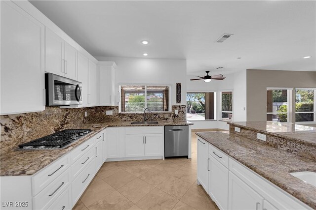 56 Grossinger Ct, Henderson, NV 89074 - kitchen featuring appliances with stainless steel finishes, backsplash, recessed lighting, a ceiling fan, and light stone counters