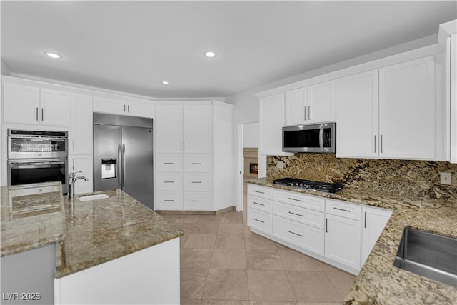 56 Grossinger Ct, Henderson, NV 89074 - kitchen with stainless steel appliances, light stone counters, white cabinetry, tasteful backsplash, and recessed lighting