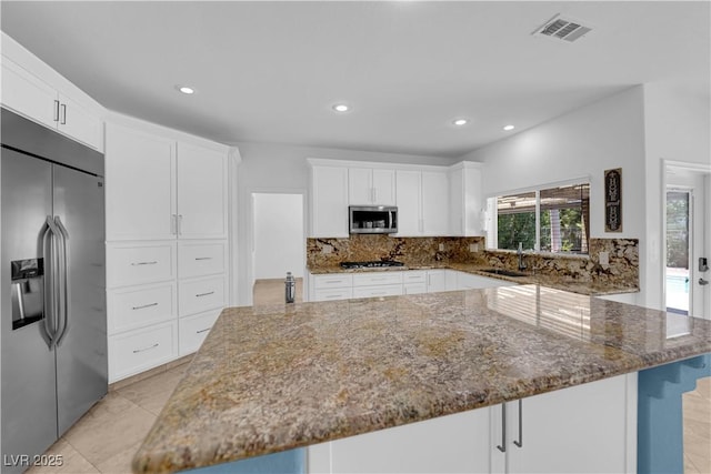 56 Grossinger Ct, Henderson, NV 89074 - kitchen with stainless steel appliances, stone counters, backsplash, a spacious island, and recessed lighting