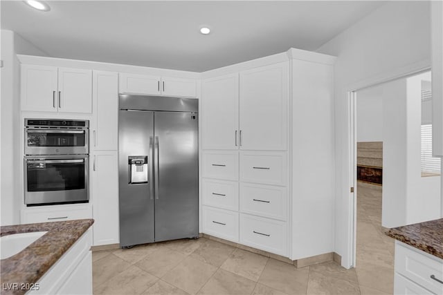 56 Grossinger Ct, Henderson, NV 89074 - kitchen featuring stainless steel appliances, dark stone countertops, recessed lighting, white cabinetry, and light tile patterned floors