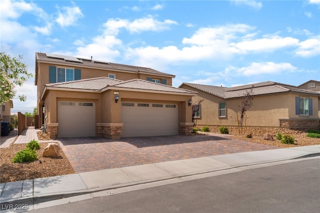 7107 Calvert Cliffs St, North Las Vegas, NV 89084 - view of front of house featuring stone siding, stucco siding, roof mounted solar panels, a garage, and driveway