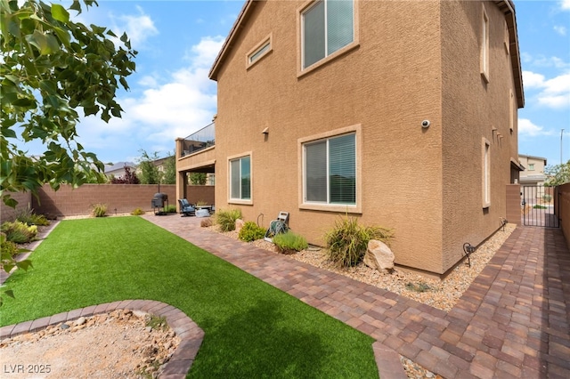 7107 Calvert Cliffs St, North Las Vegas, NV 89084 - view of side of property with stucco siding, a fenced backyard, a patio area, and a gate