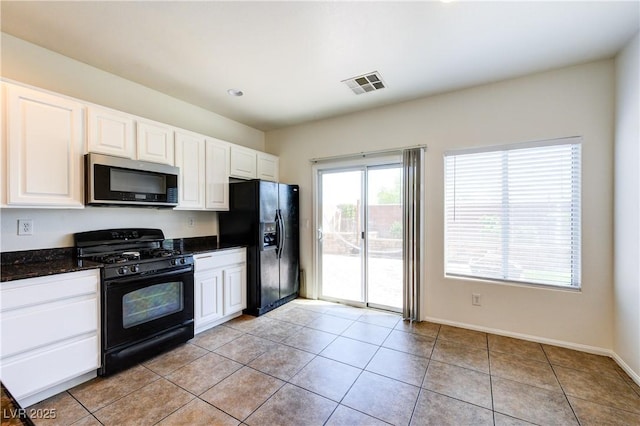 8169 Skytop Ledge Ave, Las Vegas, NV 89178 - kitchen with black appliances, white cabinets, light tile patterned floors, and dark stone counters