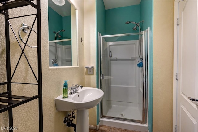 8169 Skytop Ledge Ave, Las Vegas, NV 89178 - bathroom featuring a shower stall, a textured wall, and tile patterned flooring