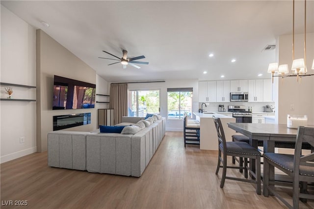 2548 Tumble Brook Dr, Las Vegas, NV 89134 - living room with light wood finished floors, ceiling fan, recessed lighting, a chandelier, and lofted ceiling