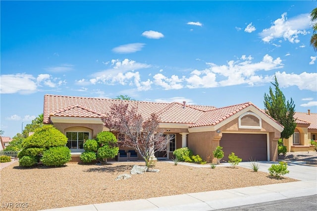 2548 Tumble Brook Dr, Las Vegas, NV 89134 - mediterranean / spanish-style home with a tile roof, an attached garage, concrete driveway, and stucco siding