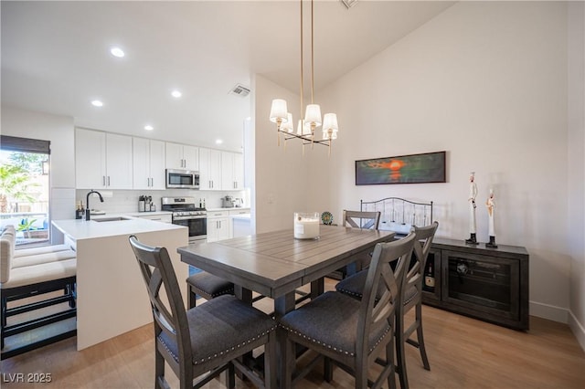 2548 Tumble Brook Dr, Las Vegas, NV 89134 - dining area with a chandelier, light wood-style flooring, and recessed lighting