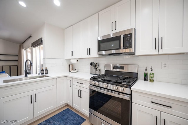 2548 Tumble Brook Dr, Las Vegas, NV 89134 - kitchen featuring stainless steel appliances, white cabinetry, tasteful backsplash, light countertops, and light wood-type flooring