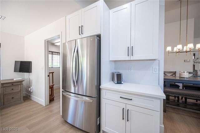 2548 Tumble Brook Dr, Las Vegas, NV 89134 - kitchen with freestanding refrigerator, white cabinetry, a chandelier, light wood finished floors, and light countertops