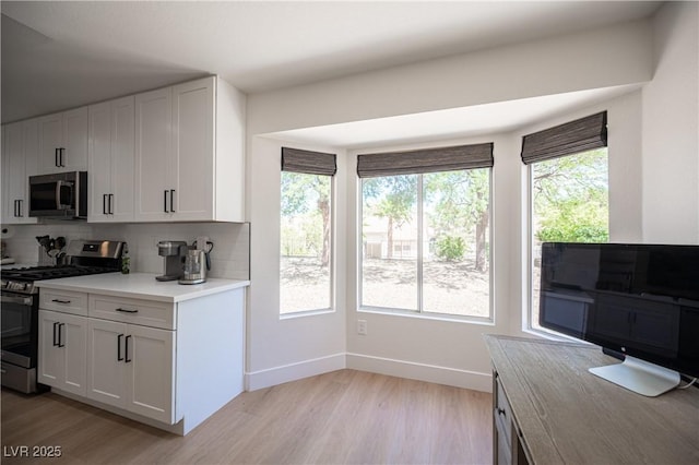2548 Tumble Brook Dr, Las Vegas, NV 89134 - kitchen featuring stainless steel appliances, decorative backsplash, light wood-type flooring, light countertops, and white cabinetry