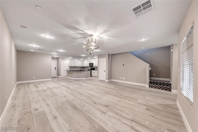 2337 Via Barranca St, Henderson, NV 89044 - unfurnished living room with a chandelier, light wood-style flooring, stairs, and recessed lighting