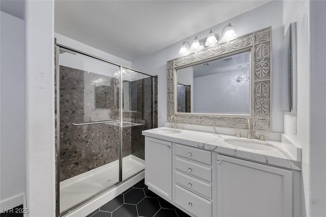 2337 Via Barranca St, Henderson, NV 89044 - bathroom with double vanity, tile patterned floors, a stall shower, and a textured ceiling