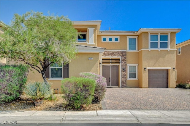 4208 Falcons Flight Ave, North Las Vegas, NV 89084 - view of front of home with stucco siding, an attached garage, stone siding, and decorative driveway