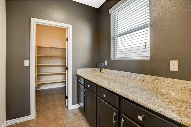 4208 Falcons Flight Ave, North Las Vegas, NV 89084 - bathroom featuring a textured wall, tile patterned floors, vanity, and a walk in closet