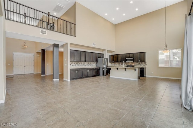 4208 Falcons Flight Ave, North Las Vegas, NV 89084 - unfurnished living room featuring a towering ceiling, light tile patterned flooring, and recessed lighting