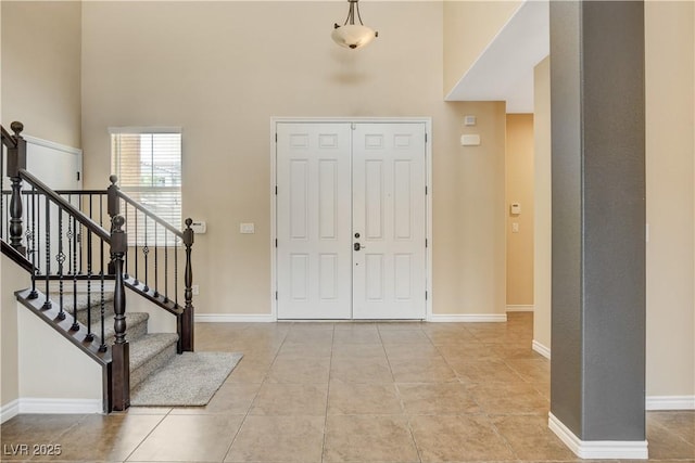 4208 Falcons Flight Ave, North Las Vegas, NV 89084 - entrance foyer featuring a high ceiling, light tile patterned flooring, and stairs