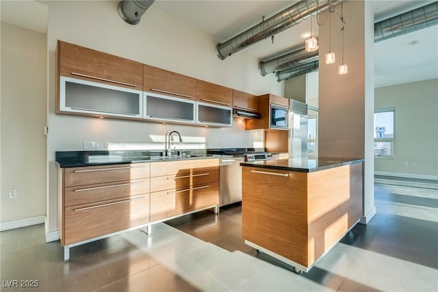 200 Hoover Ave Unit 903, Las Vegas, NV 89101 - kitchen with under cabinet range hood, a high ceiling, modern cabinets, dark countertops, and built in appliances