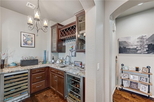 3605 Greenbriar Bluff Ave, North Las Vegas, NV 89081 - indoor wet bar with wine cooler, dark wood finished floors, arched walkways, and pendant lighting