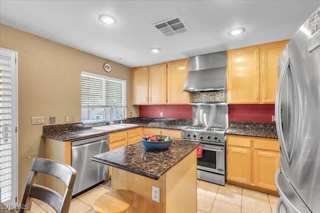 9836 La Vid Ct, Las Vegas, NV 89117 - kitchen with stainless steel appliances, wall chimney exhaust hood, light brown cabinetry, light tile patterned flooring, and a kitchen island