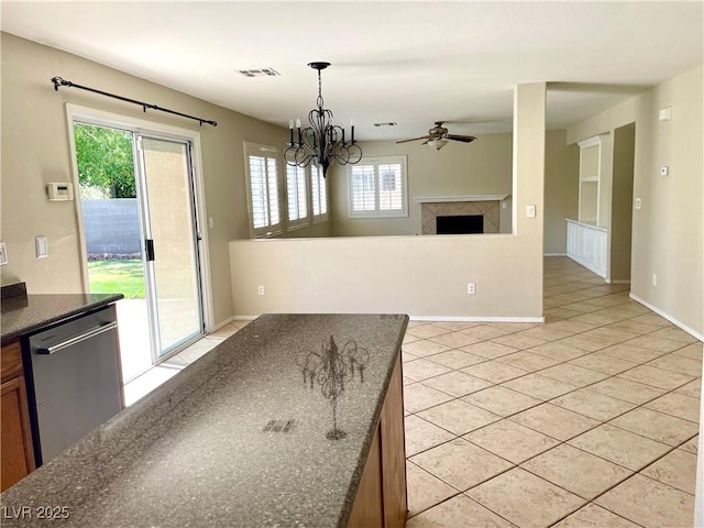 164 Swale Ln, Las Vegas, NV 89144 - kitchen with light tile patterned floors, a ceiling fan, a fireplace, stainless steel dishwasher, and hanging light fixtures